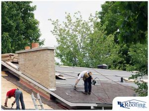 technicians installing asphalt shingle roofing on home