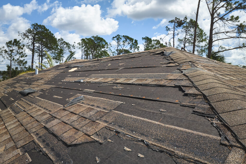 damaged-house-roof-with-missing-shingles-emergency-roof-repair-berry-roofing-riverside