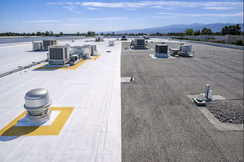Commercial flat roof maintenance showing TPO membrane and built-up cap sheet roofing systems with rooftop HVAC equipment